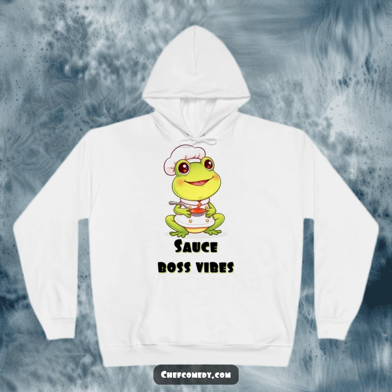 Funny frog chef tasting sauce with a smile, featured on a cozy hoodie, perfect for warmth and happiness.