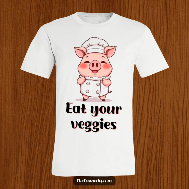 Funny t-shirt featuring a smiling cartoon pig chef proudly presenting a huge, steaming cupcake, embodying baking joy.
